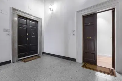 two black doors in a room with a tile floor at Navona New Exclusive Apartment in Rome