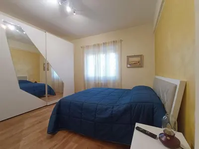 a bedroom with a blue bed and a mirror at New and beautiful house in the heart of Rome in Rome
