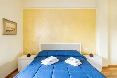 a blue bed with two white towels on it at New and beautiful house in the heart of Rome in Rome