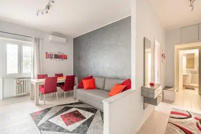 a living room with a couch and a table with red pillows at New and beautiful house in the heart of Rome in Rome