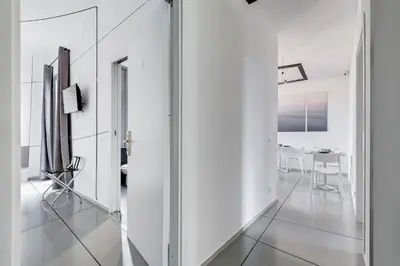 a hallway with white walls and mirrors at The Upper Suites in Rome