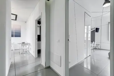 a white hallway with white walls and glass doors at The Upper Suites in Rome