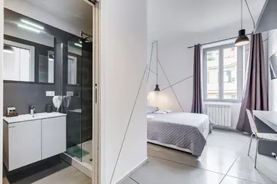 a bedroom with a bed and a sink and a mirror at The Upper Suites in Rome