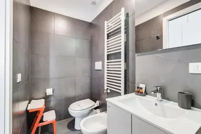 a bathroom with a white toilet and a sink at The Upper Suites in Rome