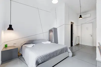 a white bedroom with a bed and a table at The Upper Suites in Rome
