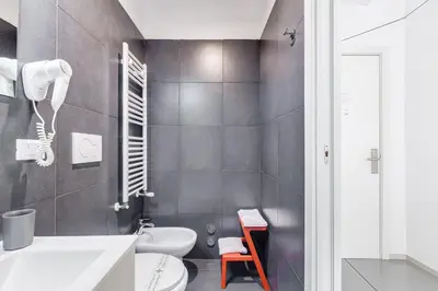 a bathroom with a white toilet and a sink at The Upper Suites in Rome