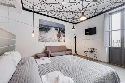 a bedroom with a bed and a couch and a tv at The Upper Suites in Rome