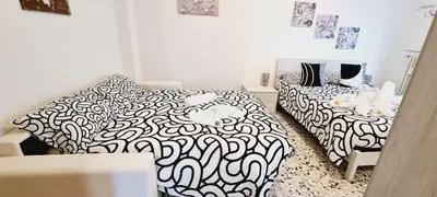a bedroom with two beds with black and white sheets at Barbara Sweet Home - Appartamento Intero in Rome
