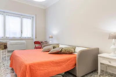 a bedroom with a bed with an orange blanket at Aurora Guest House in Rome