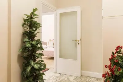 a white door in a room with a mirror at Aurora Guest House in Rome
