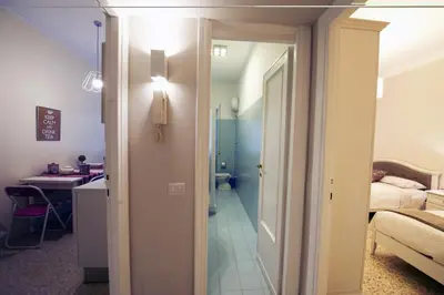 a room with a bathroom and a bedroom with a bed at Aurora Guest House in Rome