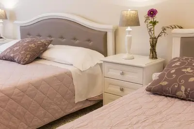 a bedroom with two beds and a table with a lamp at Aurora Guest House in Rome