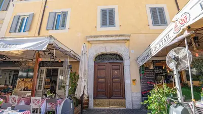 a building with a wooden door in front of a store at EasyTopStay - Campo de' Fiori Pinky House in Rome