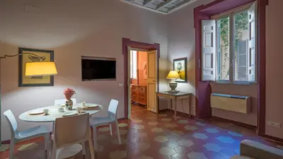 a dining room with a table and chairs and a television at EasyTopStay - Campo de' Fiori Pinky House in Rome