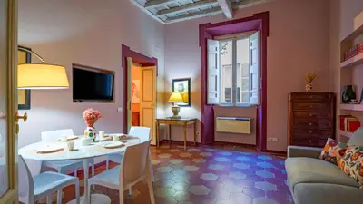 a living room with a table and a couch at EasyTopStay - Campo de' Fiori Pinky House in Rome