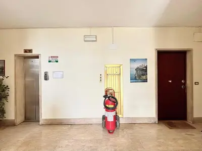 a red fire hydrant in a room with two doors at Room Ostiense in Rome