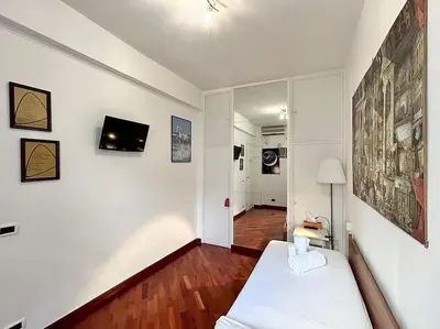 a living room with a white bed and a hallway at Room Ostiense in Rome