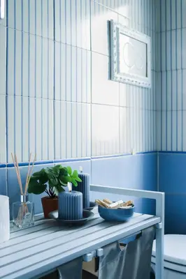 a blue and white tiled bathroom with a table with dishes at Milvio22 Apartment in Rome