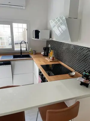 a kitchen with white cabinets and a counter top at Brando Apartment II in Rome