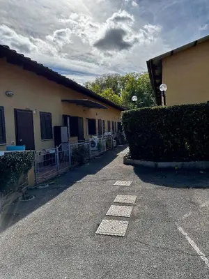 a building with a hedge in a parking lot at Casa Marlon Pietralata in Rome
