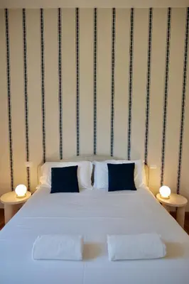 a white bed with two pillows and two tables at Livia86 - Trastevere in Rome