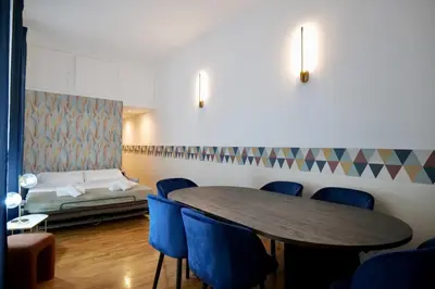 a room with a table and blue chairs and a bed at Livia86 - Trastevere in Rome