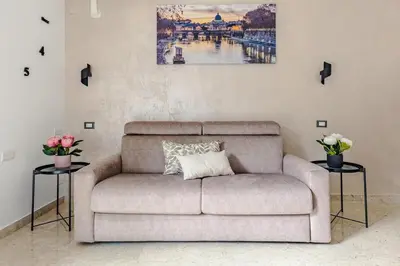 a living room with a couch and two tables with flowers at La Bellavita Trastevere in Rome