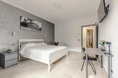 a bedroom with a white bed and a desk at La Bellavita Trastevere in Rome