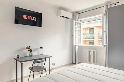 a bedroom with a bed and a table and a window at La Bellavita Trastevere in Rome