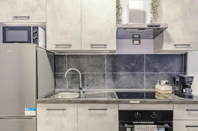 a kitchen with white cabinets and a sink at La Bellavita Trastevere in Rome
