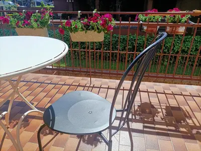 a table and a chair next to a table and flowers at Domus Marco Aurelio in Rome