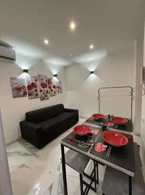 a living room with a table and a black couch at Casa vacanze Flaminia in Rome