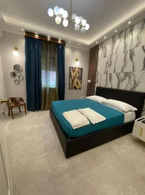 a bedroom with a large bed with blue sheets at 2Effe apartment in Rome