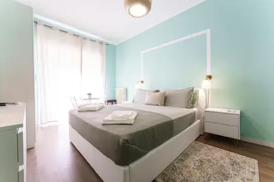 a bedroom with a large bed with blue walls at Good Vibes Vaticano in Rome