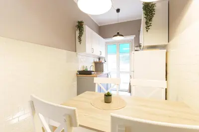 a kitchen and dining room with a wooden table and chairs at Good Vibes Vaticano in Rome