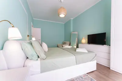 a bedroom with a white bed and a flat screen tv at Good Vibes Vaticano in Rome
