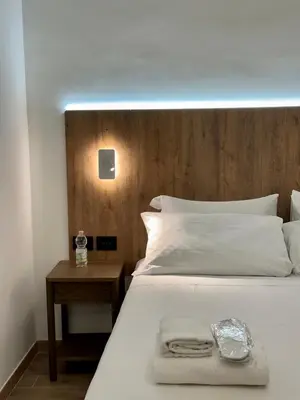a bedroom with a white bed with a wooden headboard at Domus house in Rome