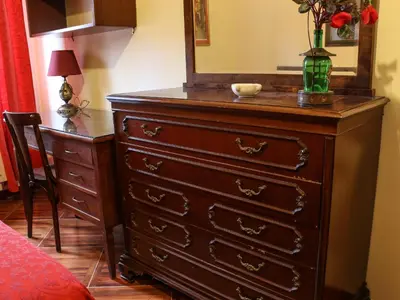 a dresser with a mirror and a vase of flowers on top at Casa Vacanze Scalone in Rome
