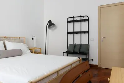 a bedroom with a large white bed and a lamp at B&D Dolce Vita in Rome