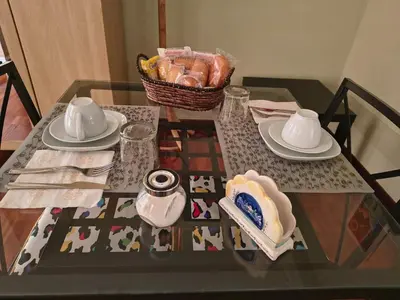 a glass table with plates and a basket of food at Gregory B&B Vatican in Rome
