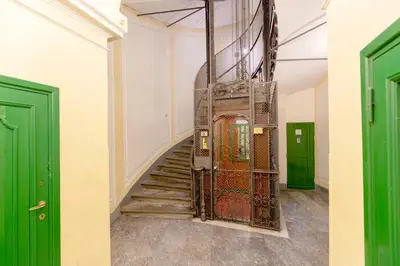 a stairway with green doors and a gate at Tiny Steps to Piazza di Spagna in Rome