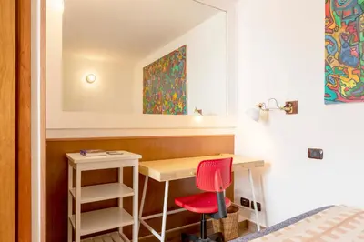 a bedroom with a desk and a red chair at Tiny Steps to Piazza di Spagna in Rome