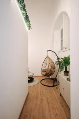 a living room with a wooden floor and a swing at 3' to Colosseum Bohèmien Paradise in Rome