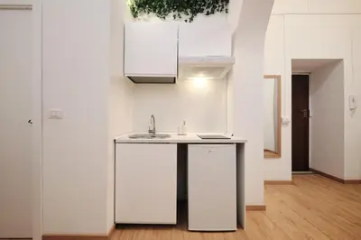 a kitchen with white cabinets and a sink at 3' to Colosseum Bohèmien Paradise in Rome