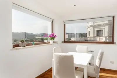 a white dining room with a white table and chairs and a window at LaDolcevita - Ponte Milvio Stunning View Penthouse in Rome