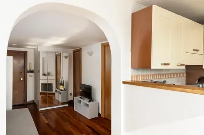 an open kitchen with white cabinets and a living room at LaDolcevita - Ponte Milvio Stunning View Penthouse in Rome