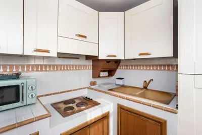 a kitchen with white cabinets and a microwave at LaDolcevita - Ponte Milvio Stunning View Penthouse in Rome