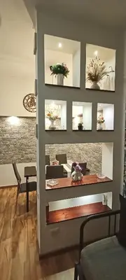 a living room with a table with flowers on a wall at Viale dei Re di Roma in Rome