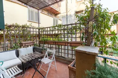 a patio with a couch and a table and chairs at Terrazza Minerva in Rome