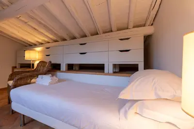a bedroom with a white bed and two chairs at Terrazza Minerva in Rome